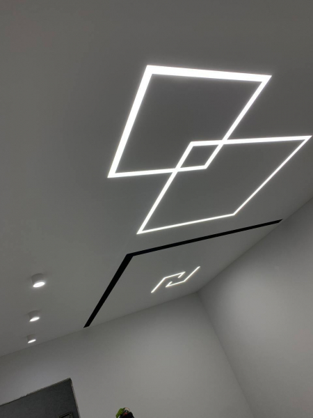 Пример матового натяжного потолка с накладными светильниками и световыми линиями